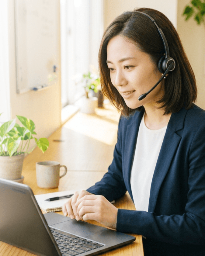 ヘッドセットを付け、ノートPC越しに1on1を行う人事担当の女性